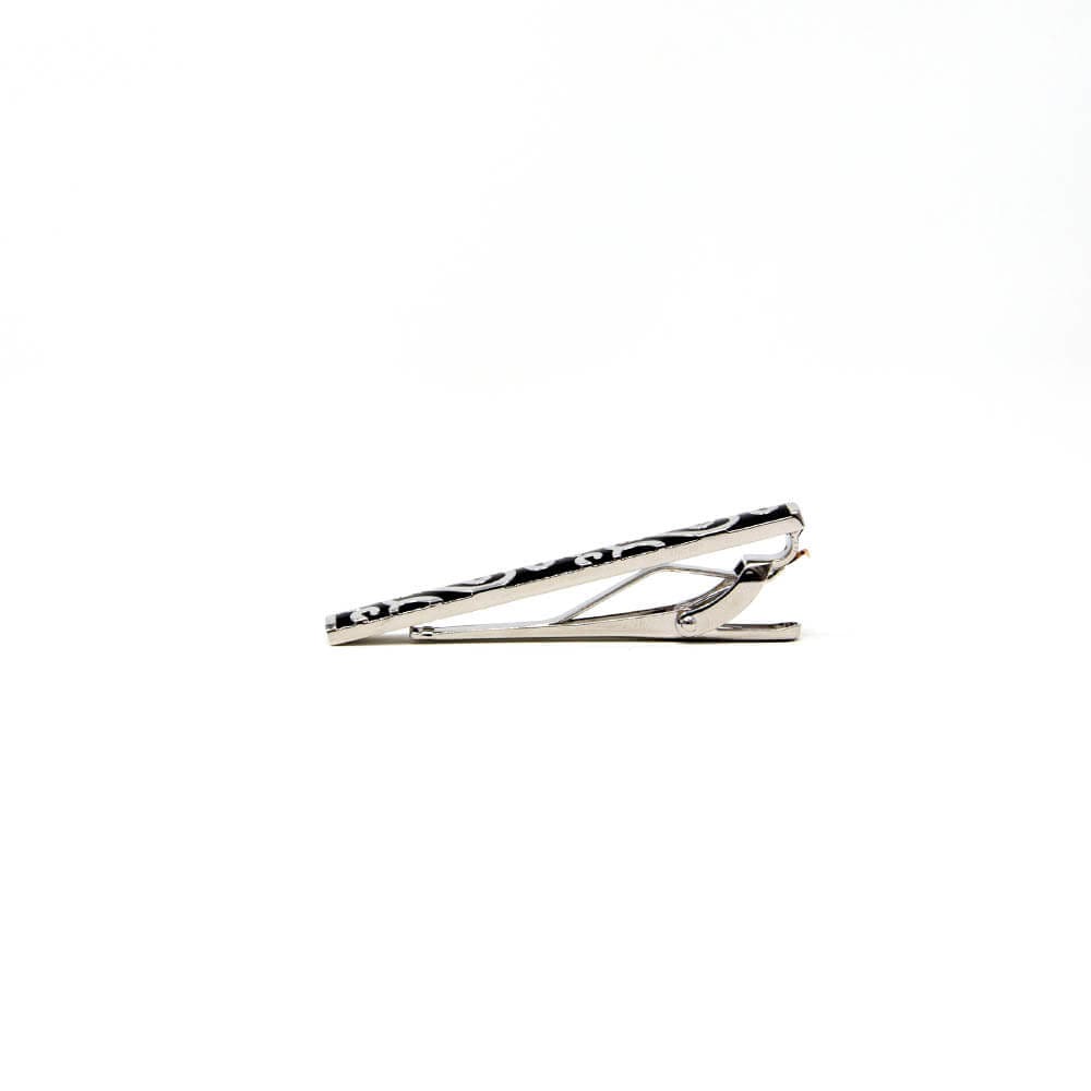 A silver tie clip with a black pattern, displaying a minimalist and elegant design, attached to a white background.