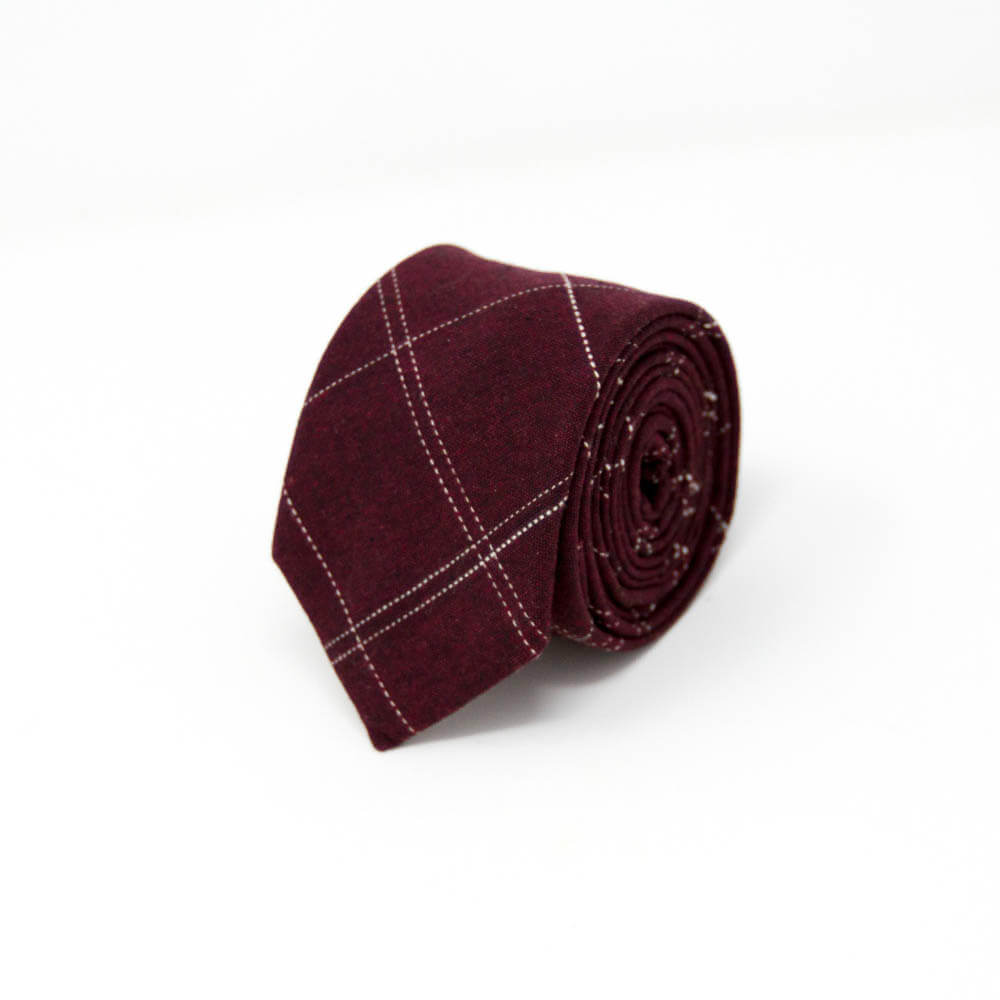 A rolled up maroon plaid tie with white lines representing the checkered pattern.