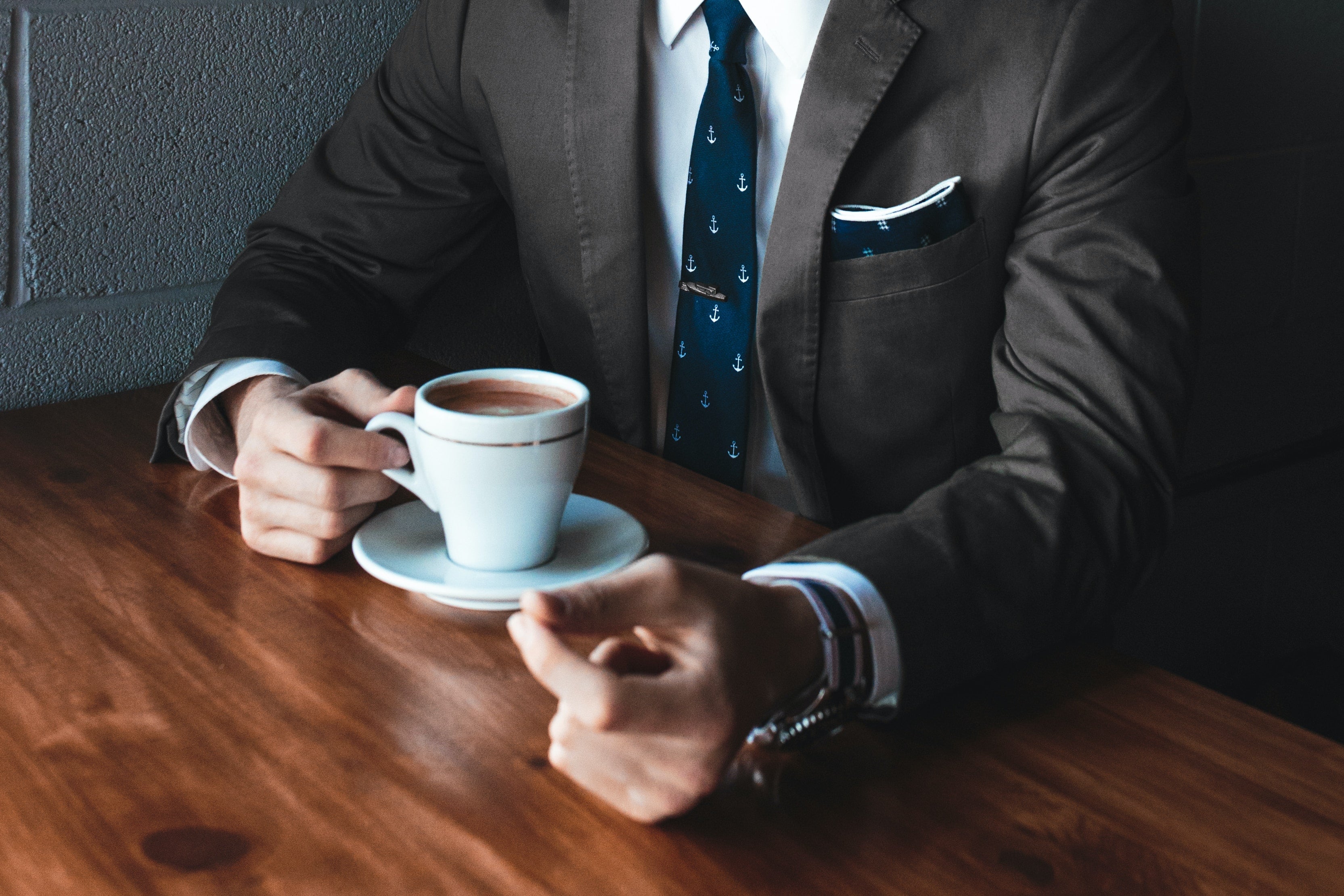 man in gray suit and navy pocket square at cafe