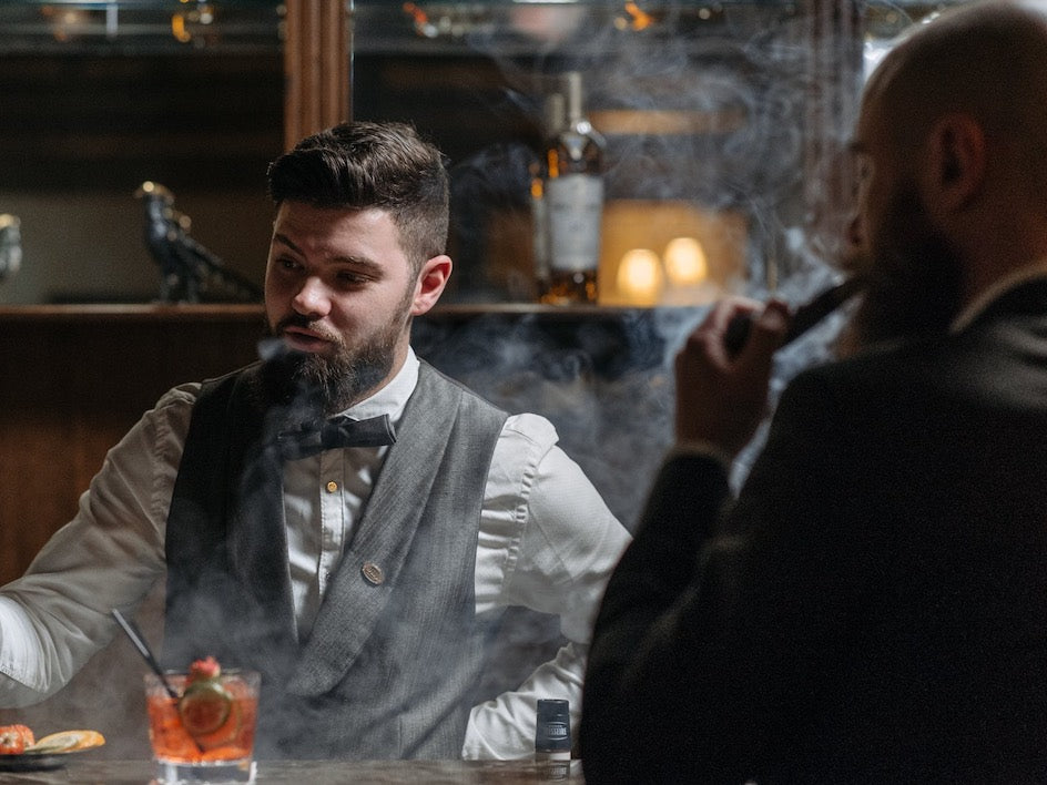 man wearing smoking jacket at vintage formal bar