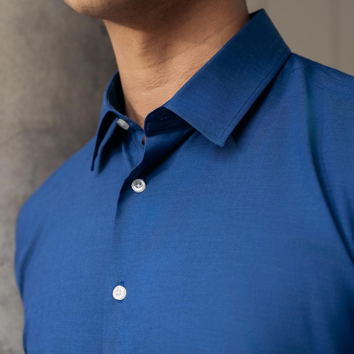 close up of blue button up collared dress shirt for men