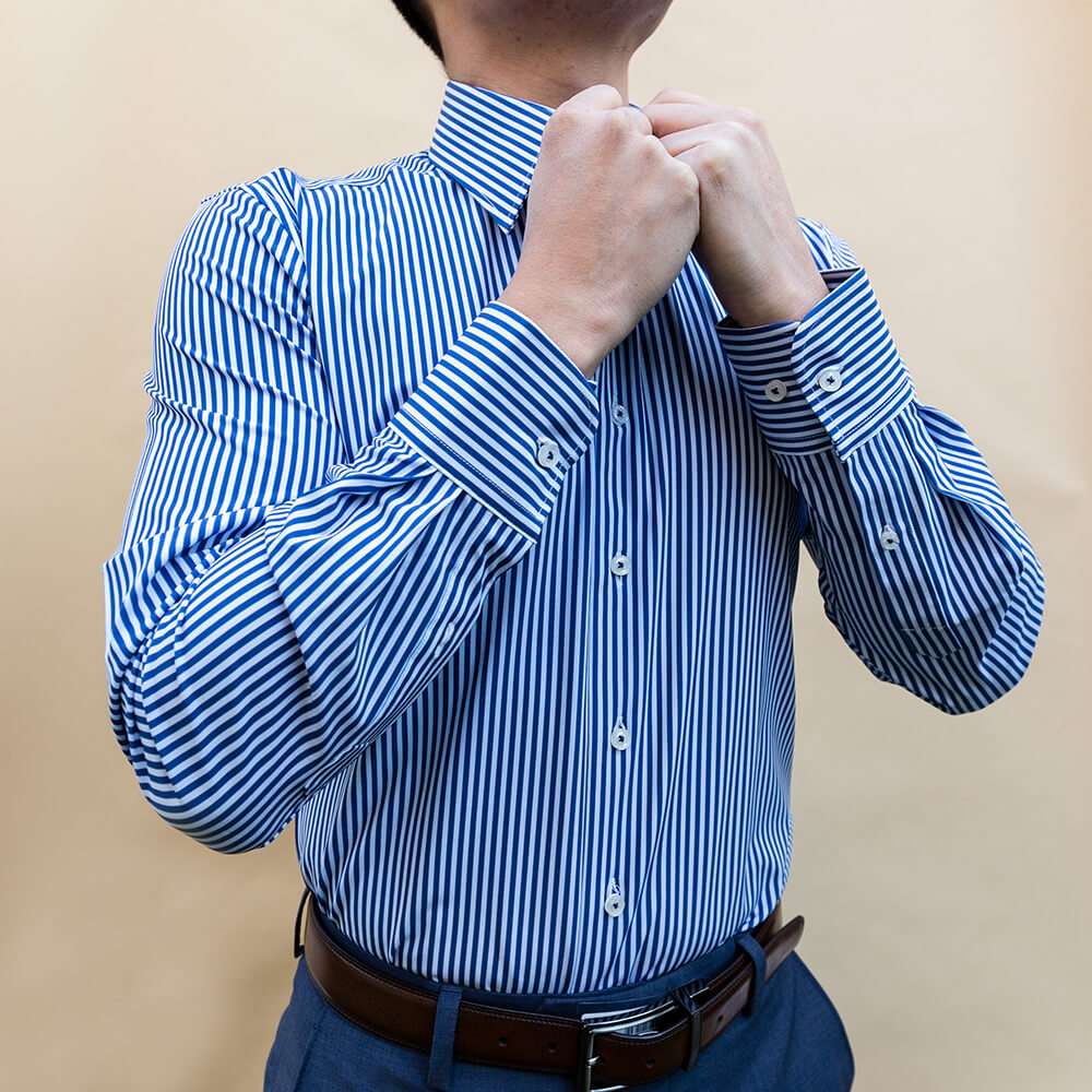 buttoning up men's blue and white striped dress shirt for business attire