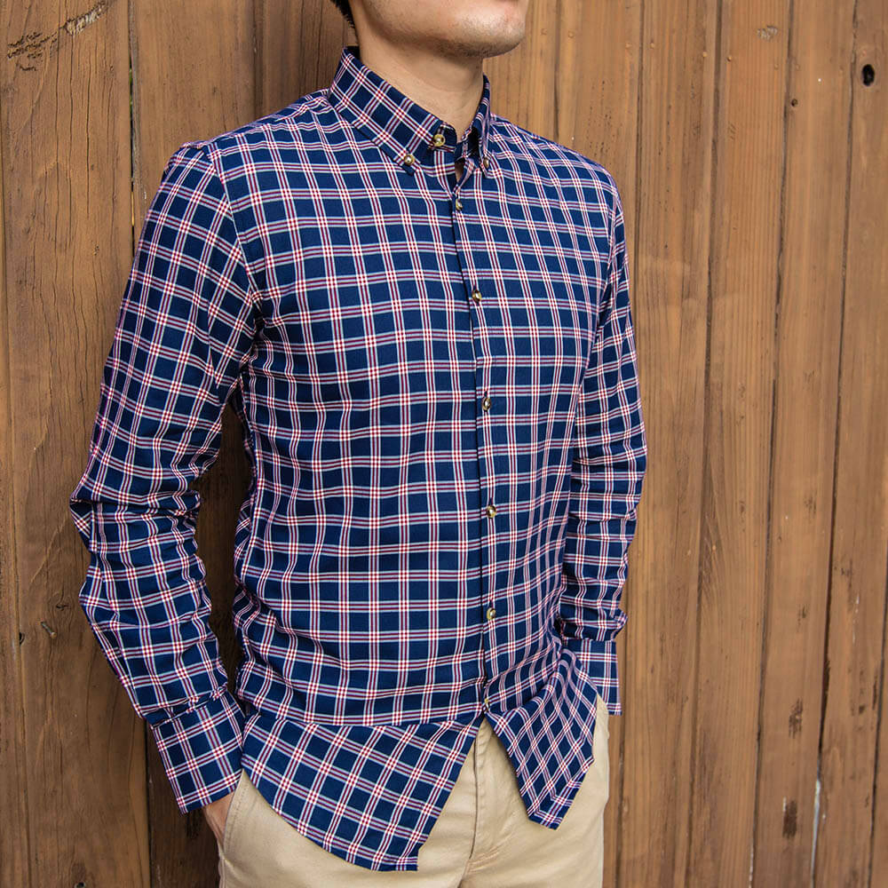 red and navy plaid shirt on male model wearing khaki pants